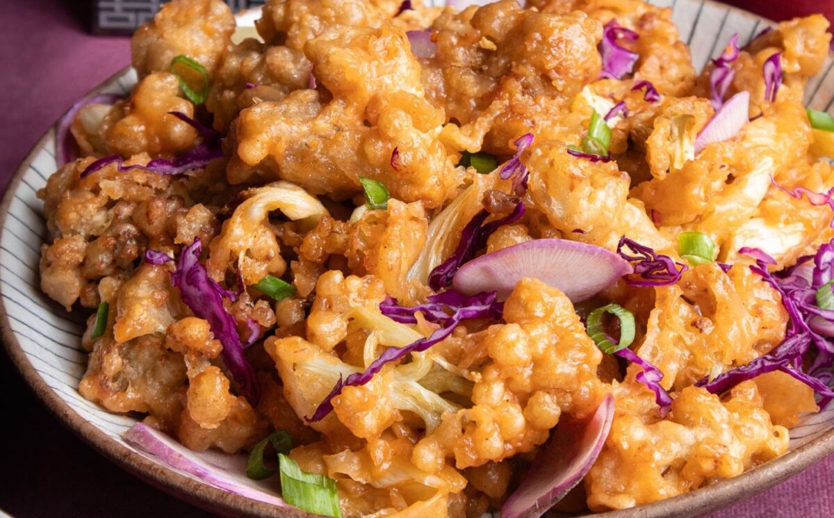 a plate of fried sweet and sour cauliflower with garnish for Chinese-inspired dishes