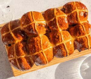 vegan hot cross bun loaf with raisins and an apricot jam glaze