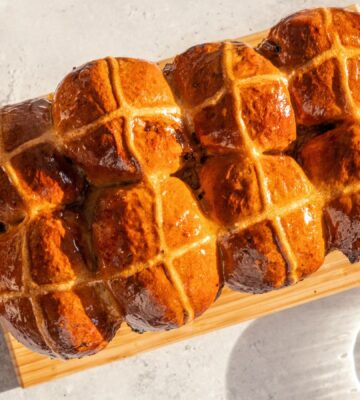 vegan hot cross bun loaf with raisins and an apricot jam glaze