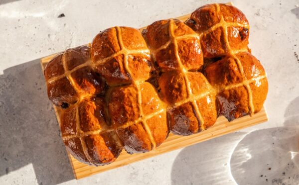 vegan hot cross bun loaf with raisins and an apricot jam glaze