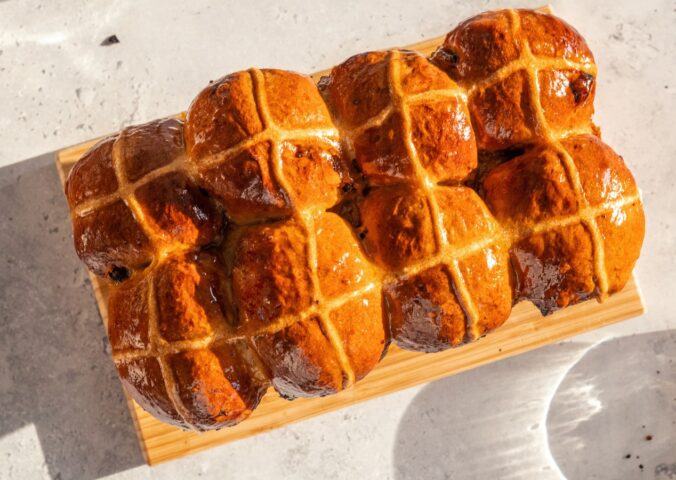 vegan hot cross bun loaf with raisins and an apricot jam glaze