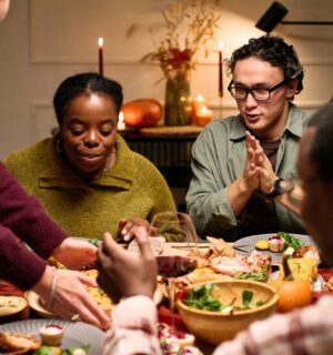 Photo shows a group of friends sitting down to a meal together. Vegans use several different types of social skills to adapt and “survive” difficulties in a predominantly meat-eating world