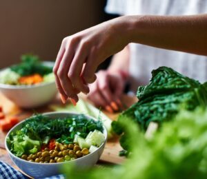 Photo shows a woman's hands as she prepares a salad with fresh fruits and vegetables and leafy greens. Vegetarians have “substantially lower” risk of five common types of cancer, according to a landmark new study.