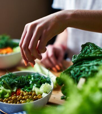 Photo shows a woman's hands as she prepares a salad with fresh fruits and vegetables and leafy greens. Vegetarians have “substantially lower” risk of five common types of cancer, according to a landmark new study.