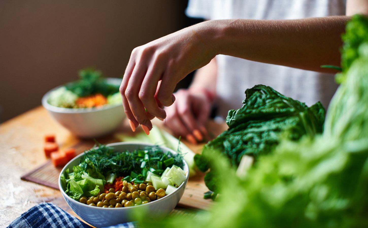 Photo shows a woman's hands as she prepares a salad with fresh fruits and vegetables and leafy greens. Vegetarians have “substantially lower” risk of five common types of cancer, according to a landmark new study.