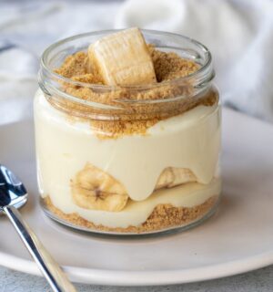 Photo shows a single serve banana pudding in a glass jar. Banana pudding is not traditionally vegan-friendly, but it can be easily made vegan with the use of common plant-based ingredients like coconut cream and oat milk