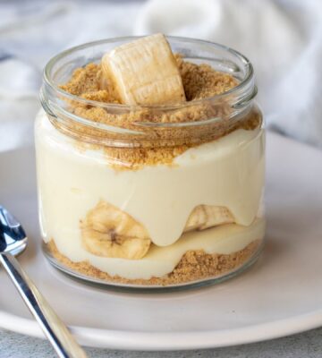 Photo shows a single serve banana pudding in a glass jar. Banana pudding is not traditionally vegan-friendly, but it can be easily made vegan with the use of common plant-based ingredients like coconut cream and oat milk