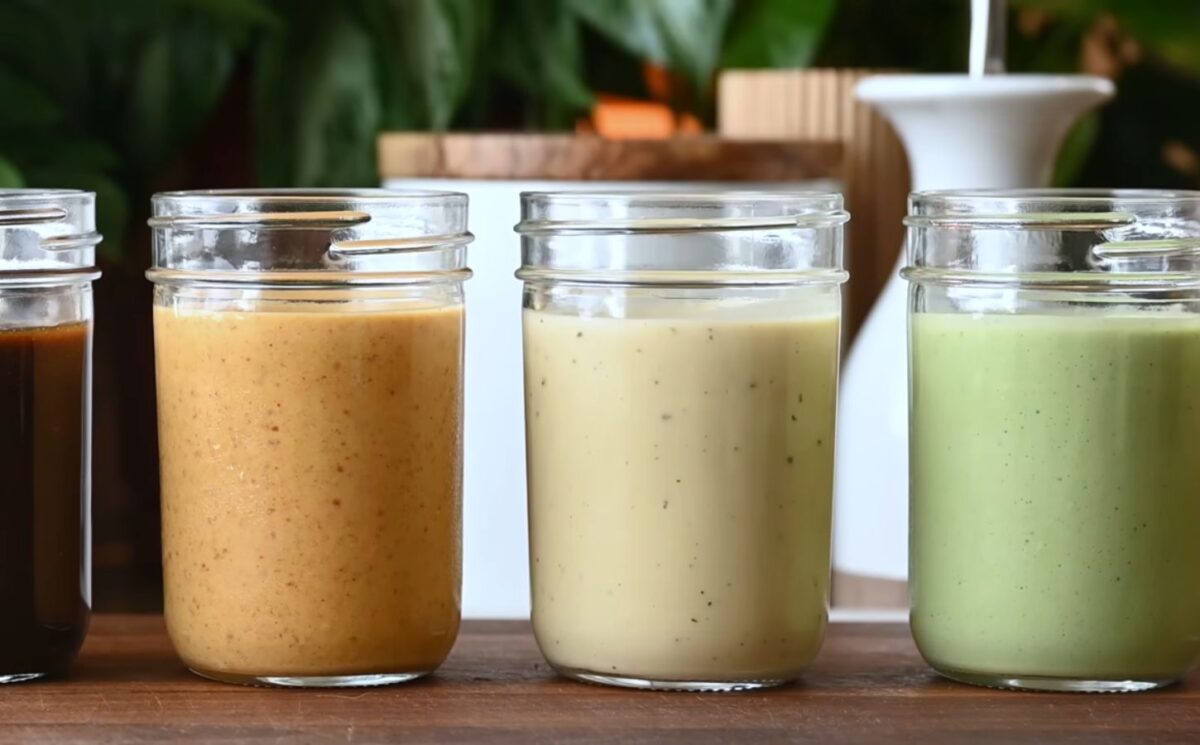 Several jars of Nisha Vora's homemade salad dressings lined up on a cutting board.