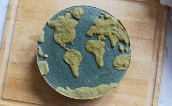 Shot of Couse's Earth Day vegan cheesecake with a green land-inspired layer and a blue one representing the ocean