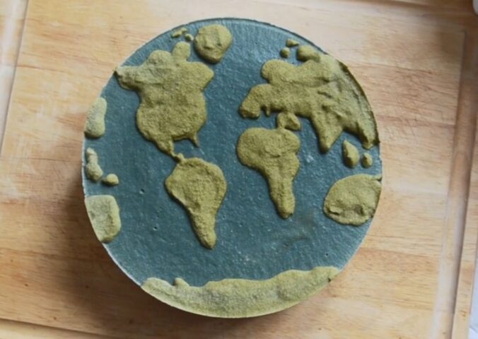 Shot of Couse's Earth Day vegan cheesecake with a green land-inspired layer and a blue one representing the ocean