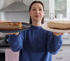 Shot of Maddie holding up two slices of vegan cheesecake that she will analyze, to test the flavor behind the viral chickpea cheesecake recipes