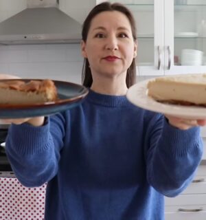 Shot of Maddie holding up two slices of vegan cheesecake that she will analyze, to test the flavor behind the viral chickpea cheesecake recipes
