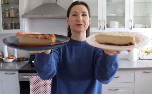 Shot of Maddie holding up two slices of vegan cheesecake that she will analyze, to test the flavor behind the viral chickpea cheesecake recipes