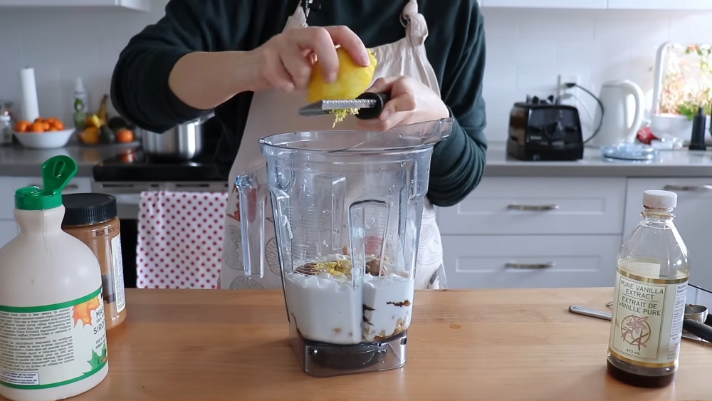 Maddie grates the lemon zest into the blender to test one of the viral chickpea cheesecake recipes