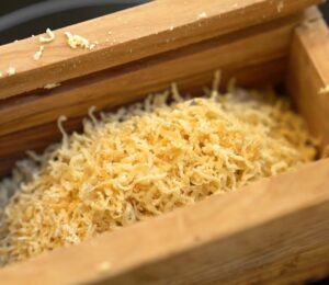 Schinner's vegan parmesan in a wooden grating box with the lid removed