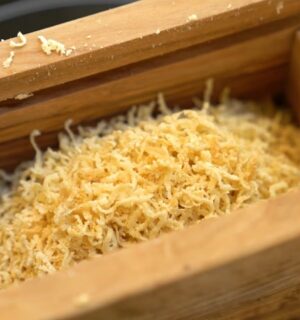 Schinner's vegan parmesan in a wooden grating box with the lid removed