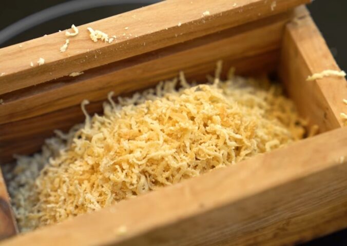 Schinner's vegan parmesan in a wooden grating box with the lid removed
