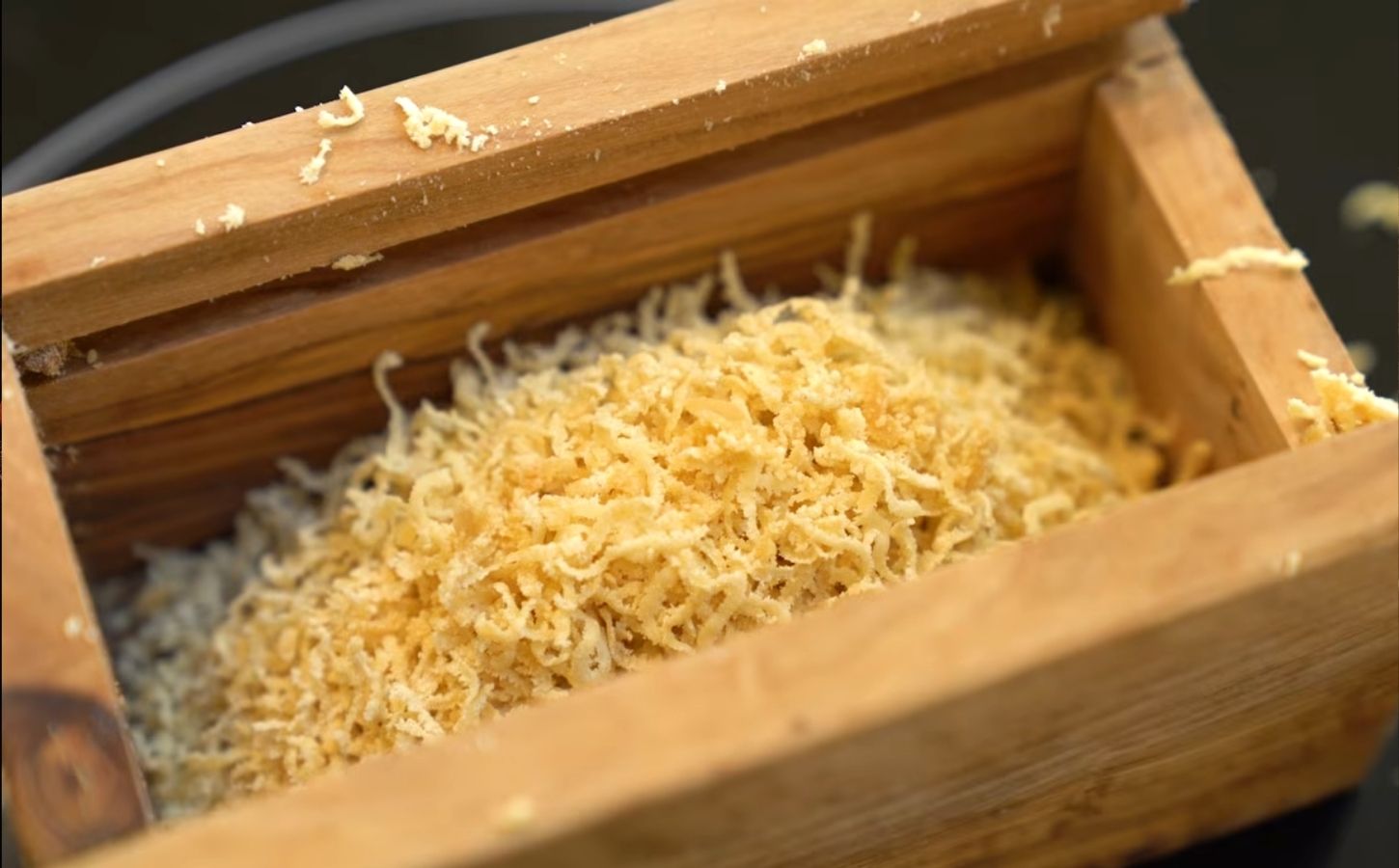 Schinner's vegan parmesan in a wooden grating box with the lid removed