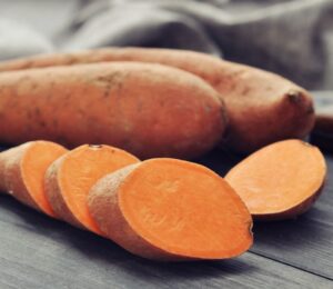 Shot of a sweet potato and one cut up in rounds to illustrate article on how to boost carotenoid absorption