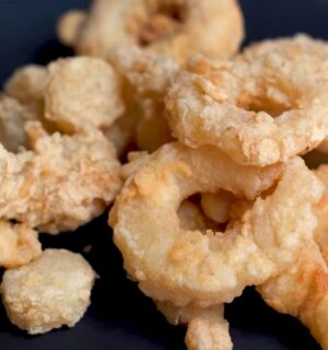 A plate of golden fried calamari rings made from konjac, using Miyoko Schinner's vegan calamari recipe.