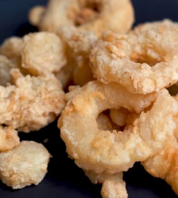 A plate of golden fried calamari rings made from konjac, using Miyoko Schinner's vegan calamari recipe.