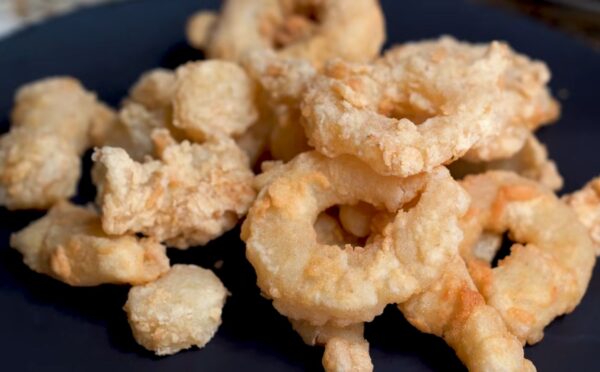 A plate of golden fried calamari rings made from konjac, using Miyoko Schinner's vegan calamari recipe.