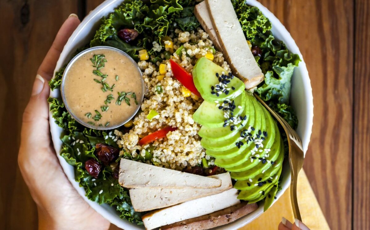 a bowl of kale salad with quinoa pilaf and creamy balsamic dressing for heart-healthy vegan recipes