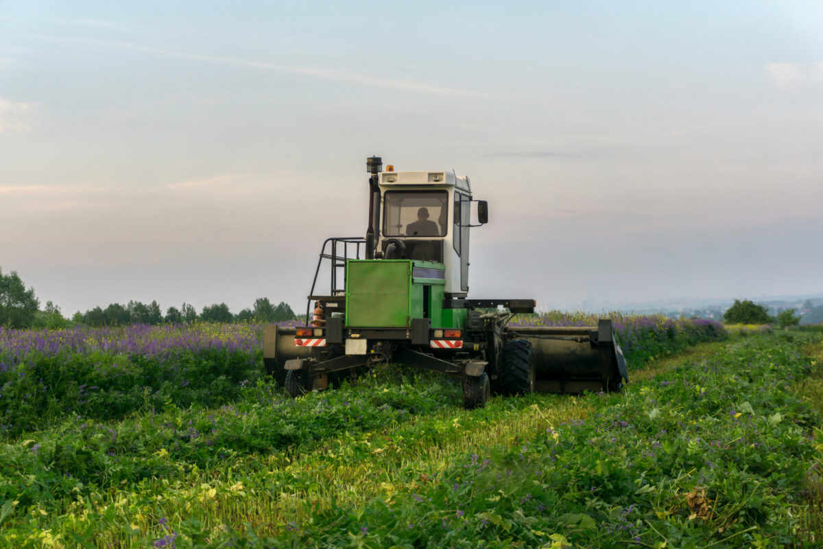 Photo shows a farmer harvesting alfalfa with a tractor. New legislation aims to expand US manufacturing of plant-based materials