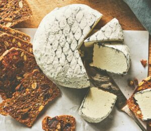A wheel of snow white rind vegan cheese like brie or camembert for vegan charcuterie