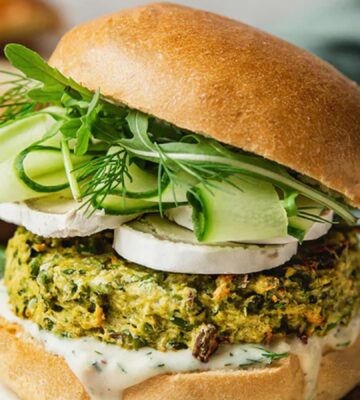 Spring Burger with courgette and pea cakes, a soy yogurt sauce, and goats cheese alternative