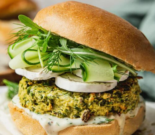 Spring Burger with courgette and pea cakes, a soy yogurt sauce, and goats cheese alternative