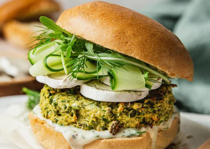 Spring Burger with courgette and pea cakes, a soy yogurt sauce, and goats cheese alternative