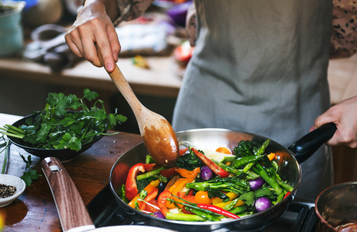 Photo shows someone cooking vegetables in a kitchen