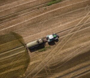 Photo shows a tractor and trailer spreading manure on a field. A new “Ammonia Map” shows that the UK’s pollution hotspots correlate with factory farms