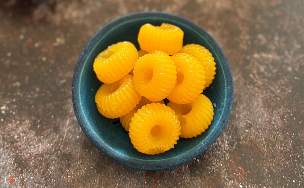 two-ingredient vegan mandarin gummies made with juice and agar agar in a cute circular mold for vegan citrus recipes