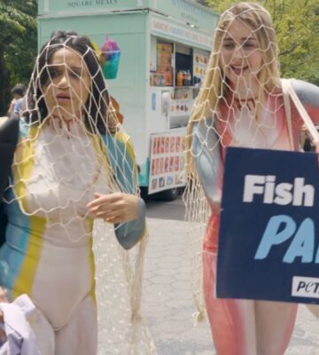 Photo shows a scene from the pilot episode of Green Goddesses Take New York, a reality comedy show from UnchainedTV that follows follows real life friends Justina Adorno and Jamie Logan as they get body-painted as endangered fish and do yoga in Times Square