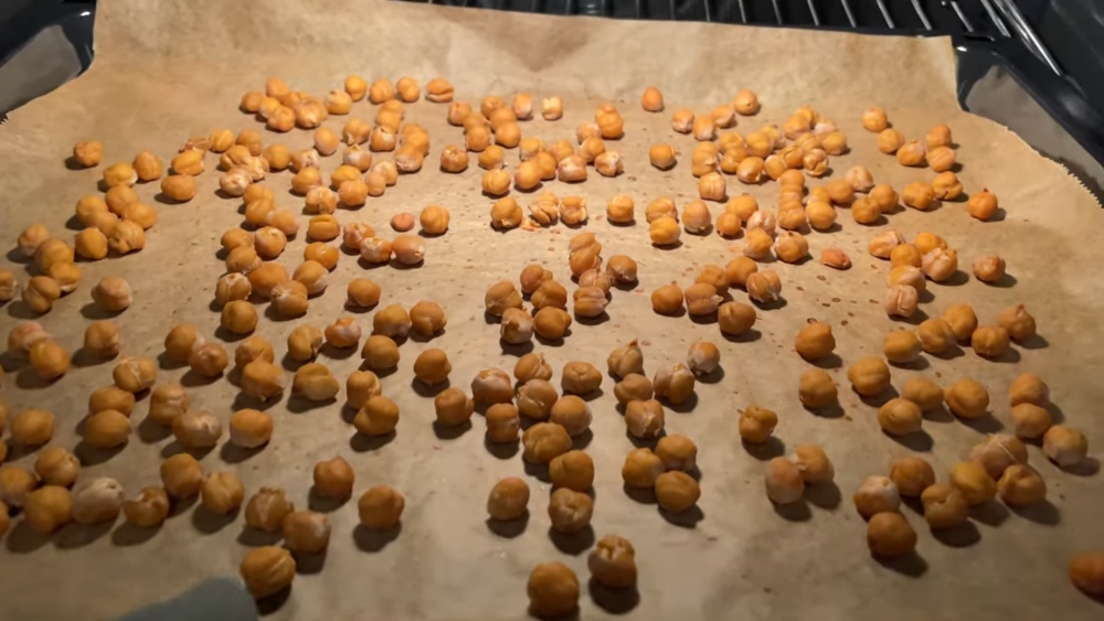 Chickpeas roasting on a baking tray lined with parchment paper to make Graf's vegan chocolate chickpea spread