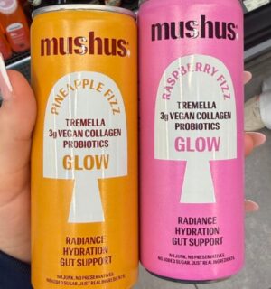 Photo shows a hand holding two flavors of the new fizzy drink, Mushus. Met Foods just launched Mushus, a range of sparkling, functional fruit drinks that target beauty and gut health