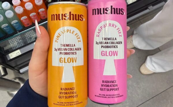 Photo shows a hand holding two flavors of the new fizzy drink, Mushus. Met Foods just launched Mushus, a range of sparkling, functional fruit drinks that target beauty and gut health