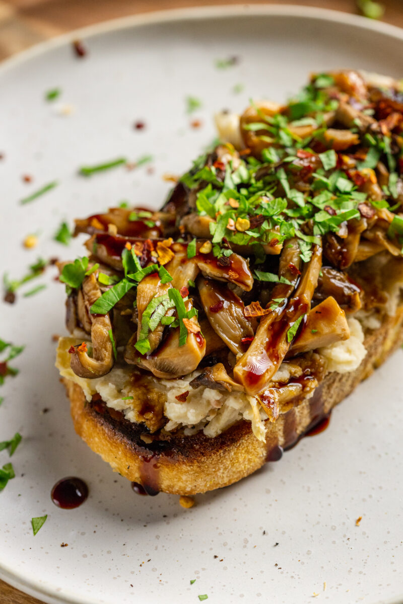 Butter Beans And Mushrooms On Toast with lemon, olive oil, artichokes, and balsamic glaze