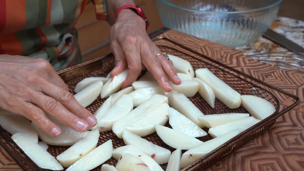 To prepare her vegan poutine recipe, Schinner places the soaked cut potatoes onto her air fryer rack