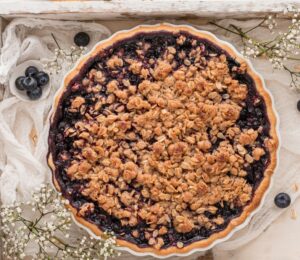 blueberry crumble pie with vegan ingredients and oat crumble