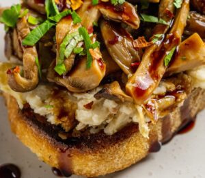 Butter Beans And Mushrooms On Toast with lemon, olive oil, artichokes, and balsamic glaze