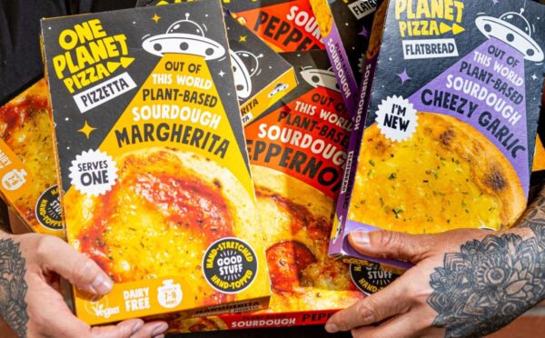Photo shows Joe Hill, the co-founder of One Planet Pizza, holding a selection of the brand's frozen vegan pizzas and cheesy garlic bread. One Planet Pizza has passed £1 million in annualised retail sales for the first time ever