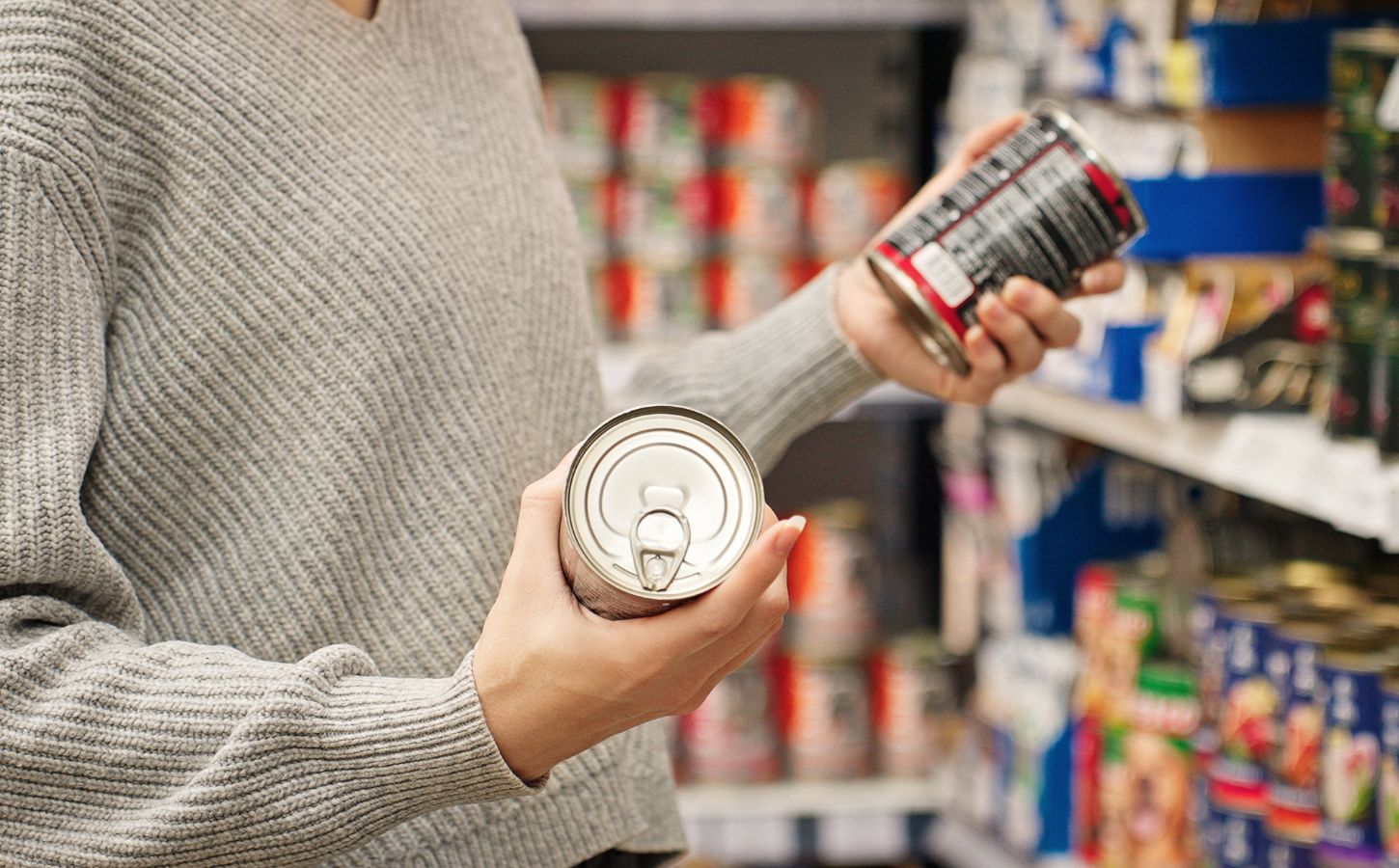 Photo shows a women holding up two cans of food in the supermarket and reading the packaging. A new study has found that people are more likely to say that they’re vegan than to actually follow a vegan diet