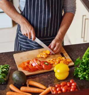 Photo shows a man cutting vegetables in a kitchen. Eating a “healthful” plant-based diet is associated with a reduced risk of Alzheimer's and other dementias, while an “unhealthful” plant-based diet is associated with increased risk