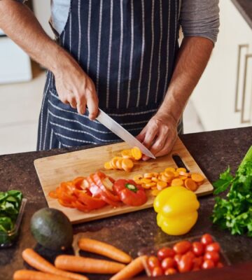 Photo shows a man cutting vegetables in a kitchen. Eating a “healthful” plant-based diet is associated with a reduced risk of Alzheimer's and other dementias, while an “unhealthful” plant-based diet is associated with increased risk