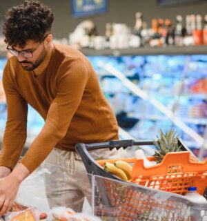 Photo shows a young man shopping in a supermarket and reaching for a pack of red meat. Plant-based mince and meatballs are currently an average of 33 percent cheaper than equivalent meat options
