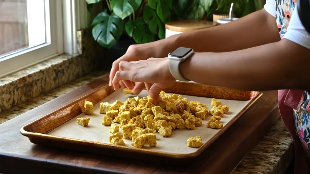 As she prepares one of two easy vegan sheet pan dinners, Vora arranges the crumbled tofu on a baking tray