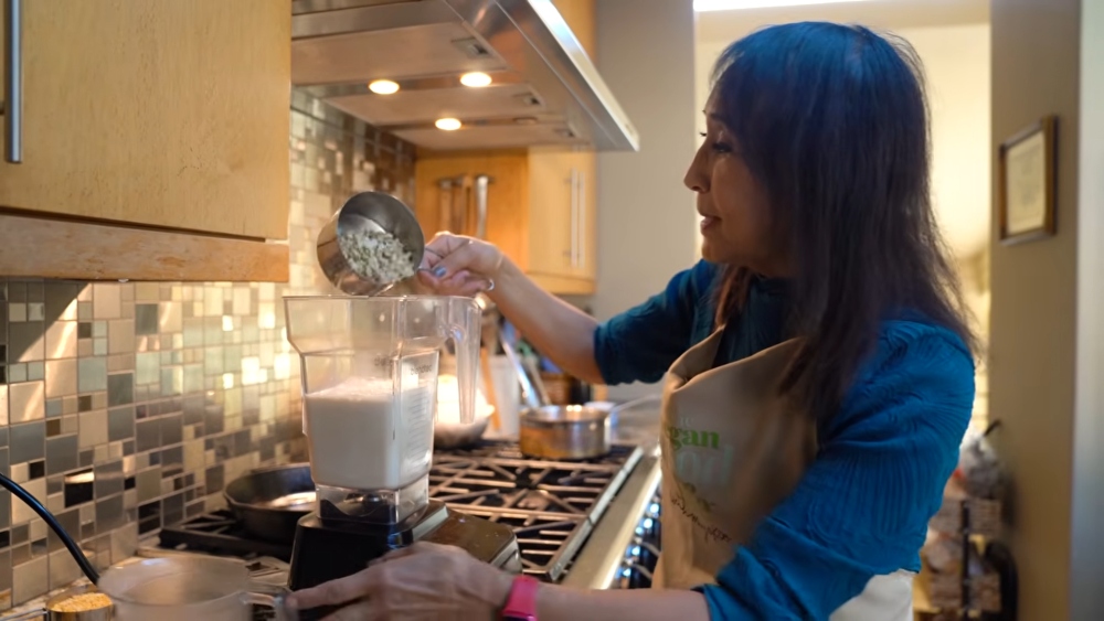 Schinner adding raw cashews to soy milk while preparing the base for her vegan yogurt from chilis.